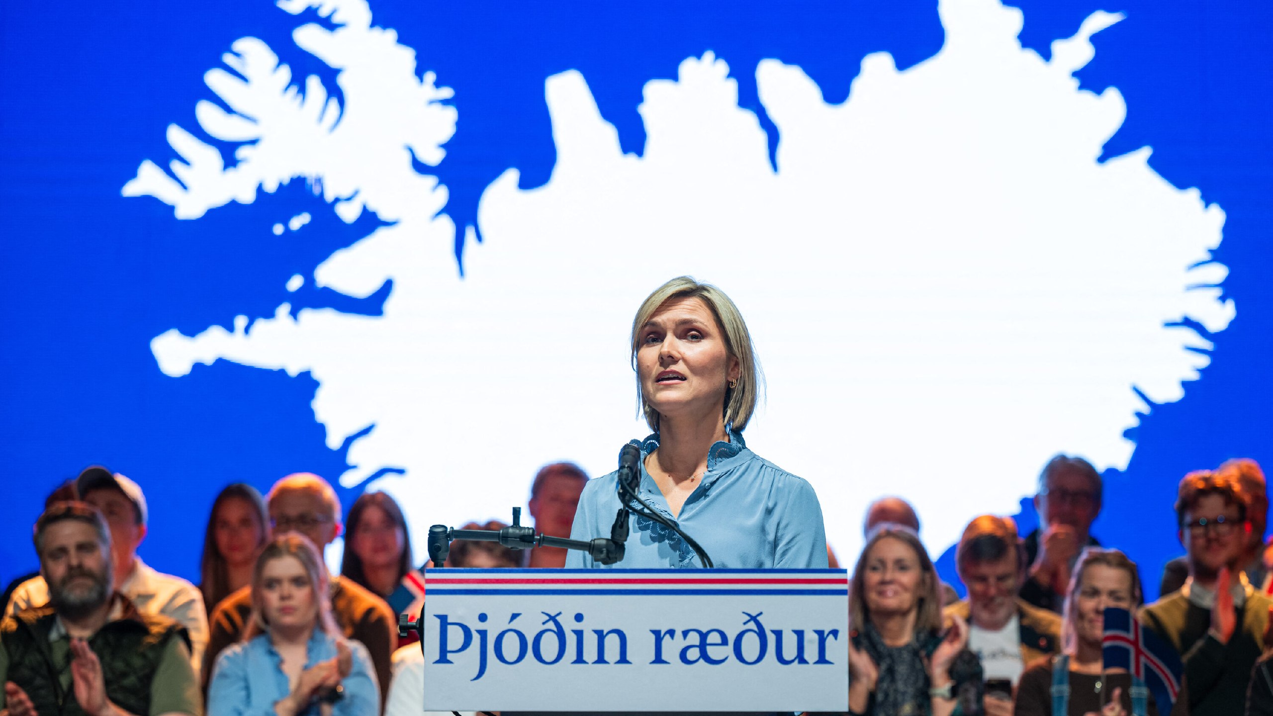 Woman Standing At A Podium With a woman standing at a podium with a map behind her